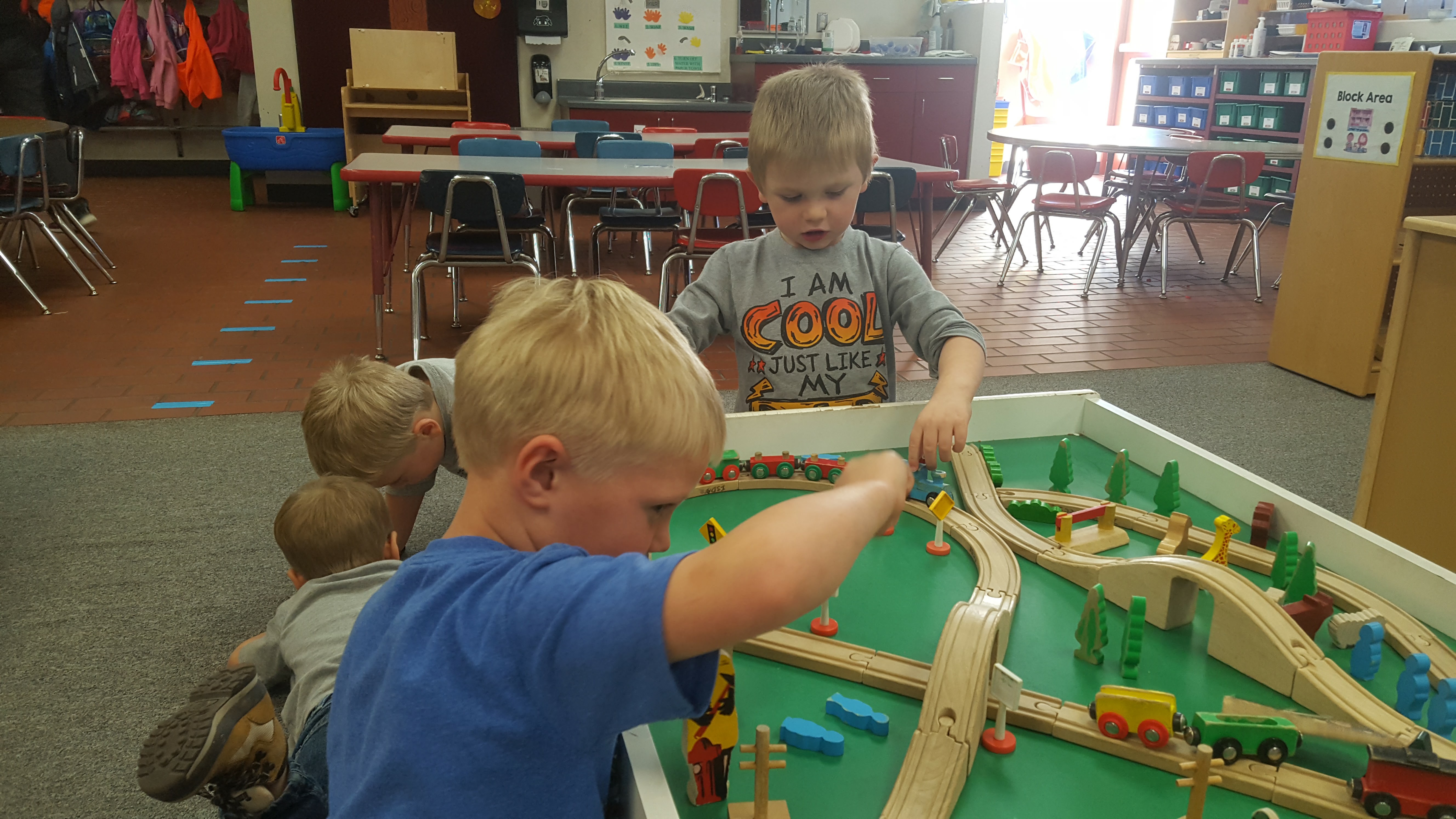 boys play on train table